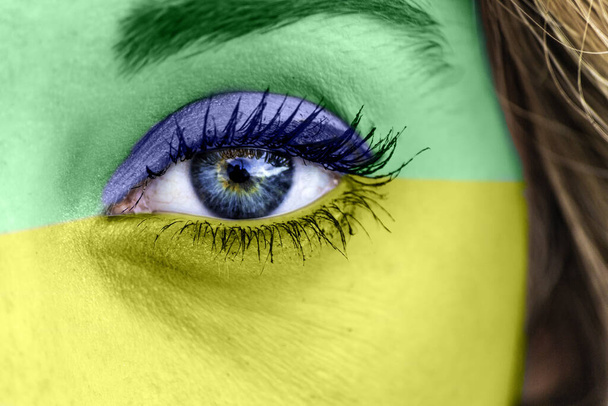 Крупный план женского глаза с цветами бразильского флага - Фото, изображение