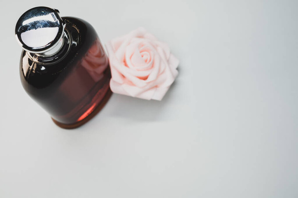 A bottle of nice perfume with a beautiful rose flower on a white background - Foto, Imagen