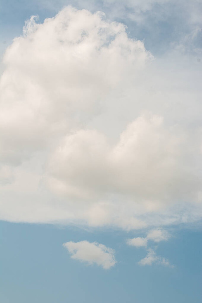 A vertical shot of fluffy white clouds in the sky - Zdjęcie, obraz