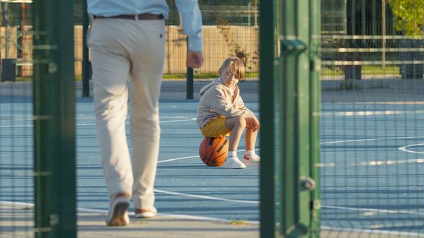 Мужчина и ребенок на баскетбольной площадке на открытом воздухе - Фото, изображение