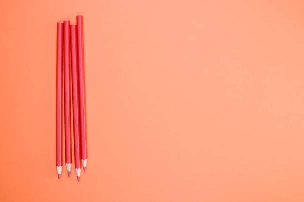 A high angle shot of red pencils on a red surface - Fotografie, Obrázek