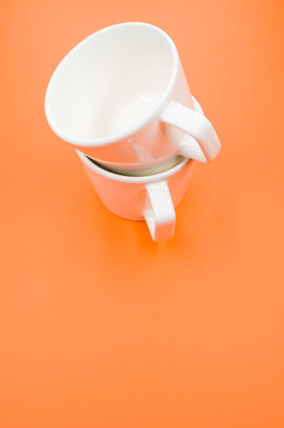 A vertical shot of two empty cups on an orange surface - Foto, immagini
