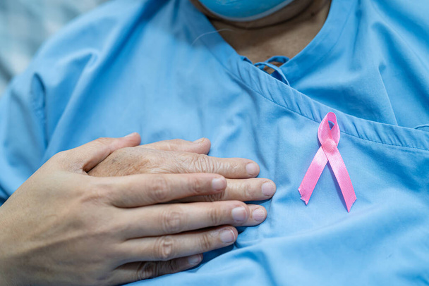 Rak piersi, różowa wstążka u azjatyckiej seniorki za wspieranie świadomości. - Zdjęcie, obraz