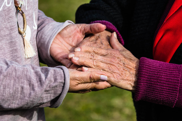 A woman holding her old mother's hand giving her hope - Photo, image
