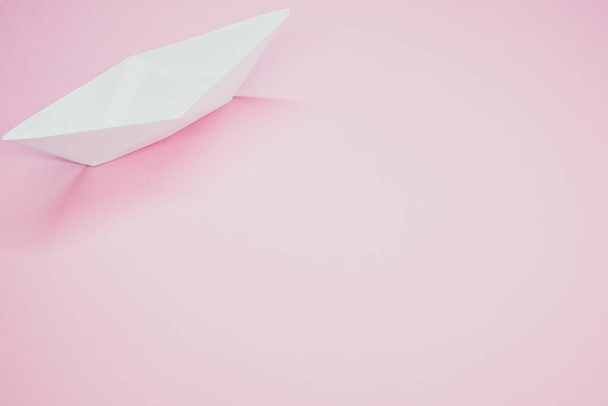 A top view of a white paper boat isolated on a pink background - Foto, Bild