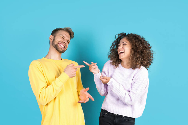 You so funny. Happy mixed race friends laughing, pointing on each other and having fun isolated on blue copy space background. Concept of positive human emotions - Фото, зображення