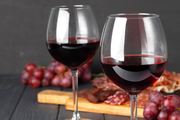 Wineglass with red wine and meat cuts board - Valokuva, kuva