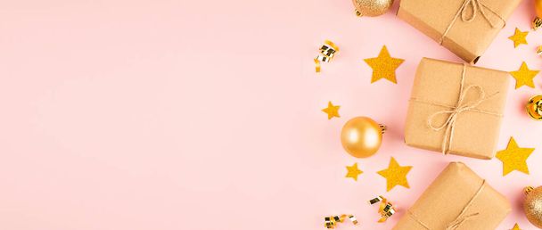Weihnachtsrahmen aus goldenen Weihnachtskugeln und Geschenkschachteln auf rosa Hintergrund. Weihnachtlicher Hintergrund. Flache Lage, Draufsicht. Kopierraum. Banner. - Foto, Bild