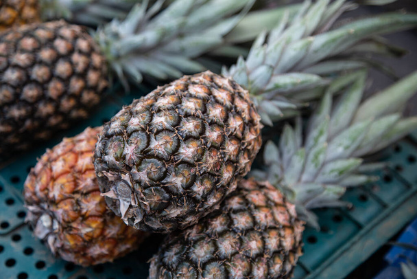 A selective focus shot of pineapples in the market - Zdjęcie, obraz