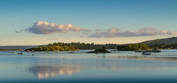 Panoramic landscape of a sunset on a lake in Ireland with clouds reflected in the water. - Fotoğraf, Görsel