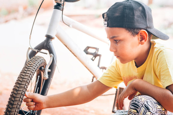 Enfant brésilien prenant soin de son nouveau vélo - Photo, image