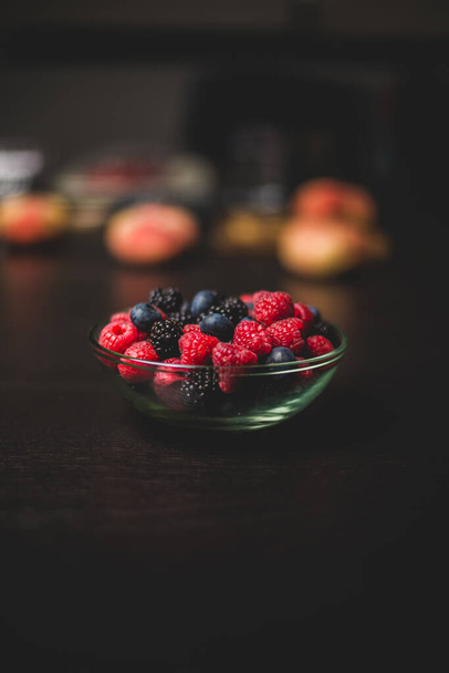 A vertical shot of fresh berries on a wooden surface - Foto, imagen