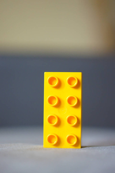 POZNAN, POLAND - Mar 19, 2016: Пластичний жовтий Lego Duplo іграшкова цегла на м'якому фоні фокусу. - Фото, зображення