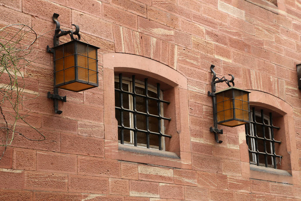A closeup of a vintage window of a house with lanterns on the wall - Фото, зображення