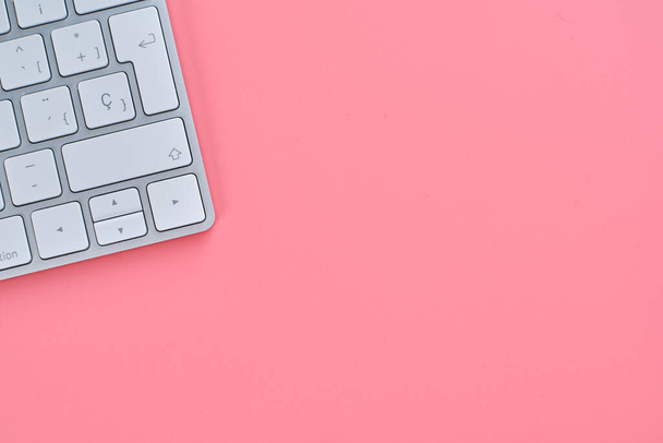 A top view of a pink background with a keyboard and copy space - Foto, immagini