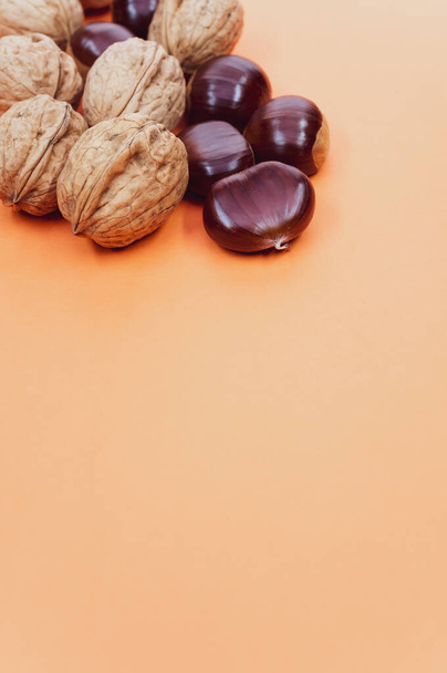 A high angle shot of a background with hazelnuts and walnuts with a copy space - Foto, Imagem