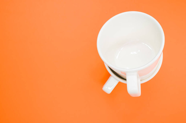A high angle shot of two empty cups on an orange surface - 写真・画像