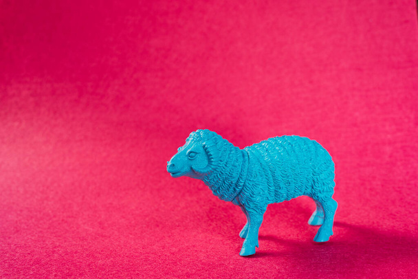 A closeup shot of a blue ram sheep figurine on a pink background - Zdjęcie, obraz