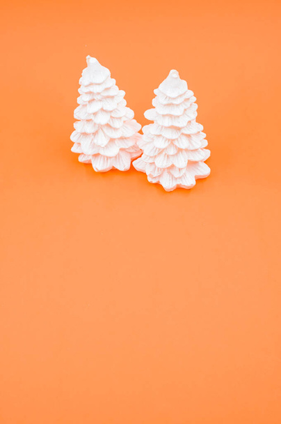 A vertical shot of Christmas ornaments on an orange surface - 写真・画像