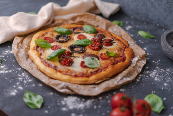 A top view of whole vegetarian pizza with mushrooms, basil, tomatoes, and cheese - Valokuva, kuva