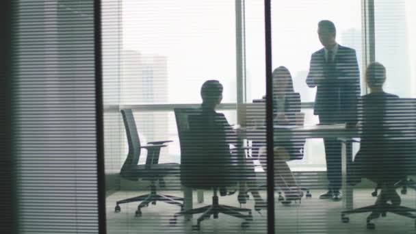 przez szklane panoramiczne zdjęcie biznesmenów pracujących w nowoczesnym biurze korporacyjnym - Materiał filmowy, wideo