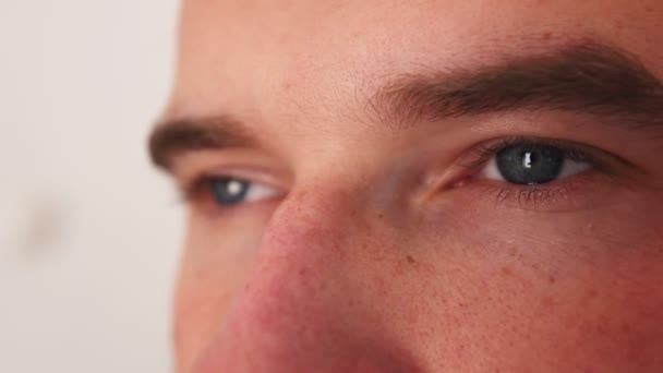 Eyes of an caucasian man. closeup view of a persons face. The man is looking at the camera. The mans gaze looks ahead. - Footage, Video