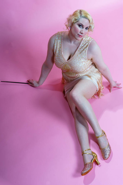 A vertical shot of a blonde female dressed as a fairy against a pink background - Foto, immagini