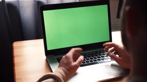 Молодой кавказский человек в домашнем офисе сидит за столом и разговаривает с ноутбуком с зеленым экраном. Мужской разговор с помощью удаленной онлайн-конференции веб-камера видеозвонок - Кадры, видео