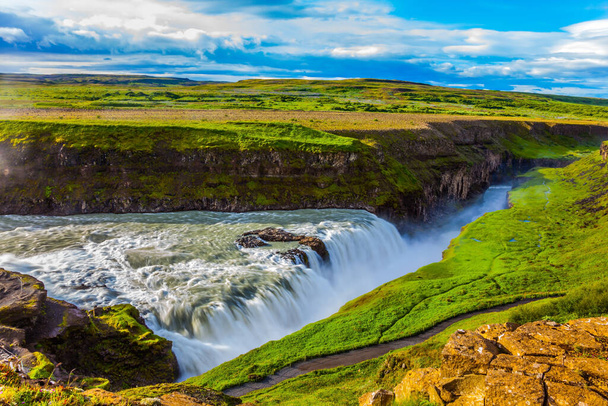 Picturesque multi-colored tundra on a sunny summer day. The most picturesque waterfall in Iceland - Gullfoss on the Hvitau River. The concept of extreme and phototourism - 写真・画像