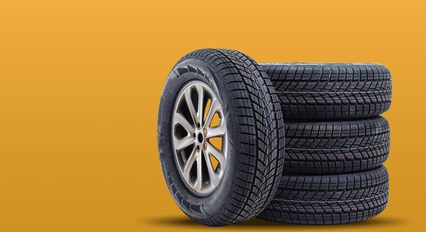 Car tires isolated on yellow background - Photo, Image