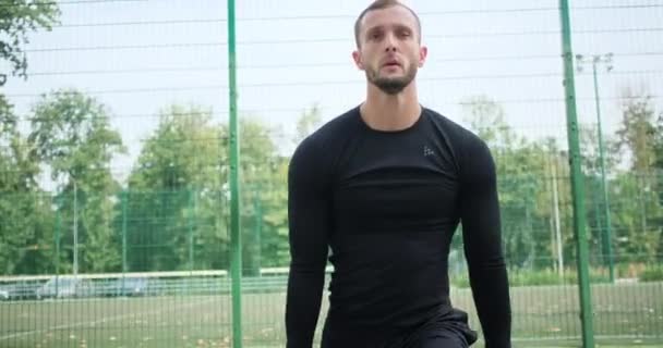 Sportman doen stretching oefening door sport grasmat - Video