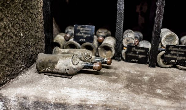 old bottles with wine stored in special cellars and stored using special technology - Foto, Imagen