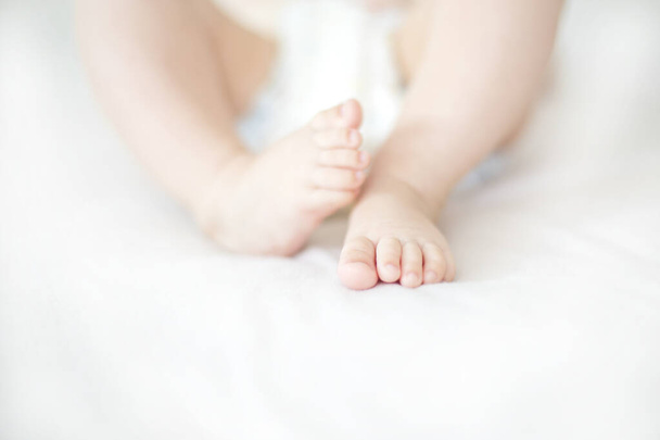View at small baby girl feet on the bed - Photo, Image