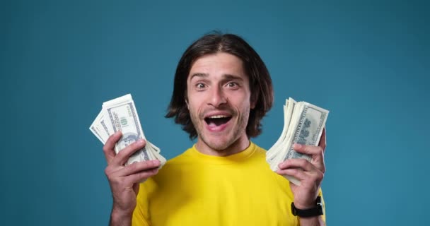Ενθουσιασμένος άνθρωπος που κατέχει δέσμη μετρητών δολάρια - Πλάνα, βίντεο