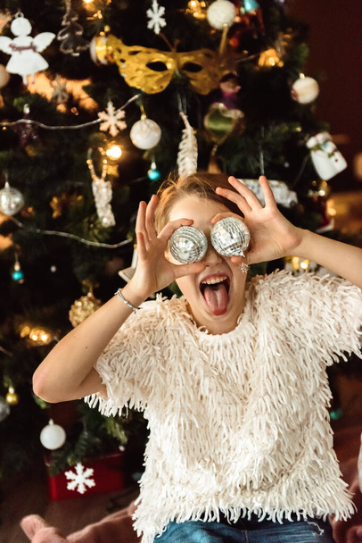Girl laughing near the Christmas tree - Fotó, kép
