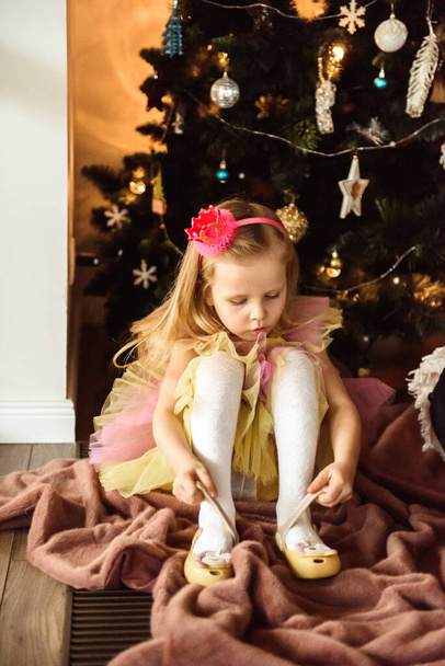 Little girl dresses up near the Christmas tree - Photo, image