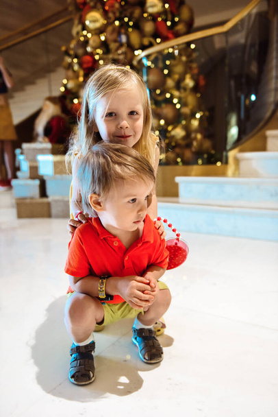 Children playing near the Christmas tree - Foto, Bild