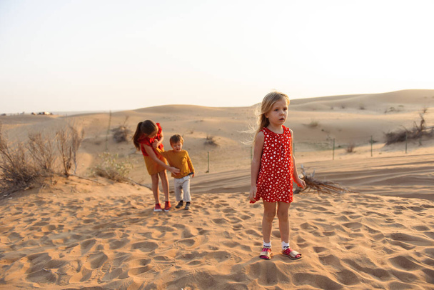 Children playing in the sands of the Emirate - 写真・画像
