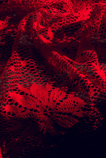 Rood gebreide stof. Rode stof gaas in een bloem. Rode textuur - Foto, afbeelding
