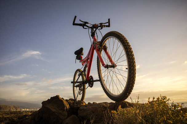 Foto van een mountainbike bij zonsondergang - Foto, afbeelding