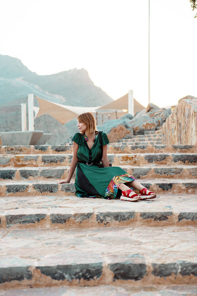 Woman sitting on stairs in Emirate mountains - 写真・画像