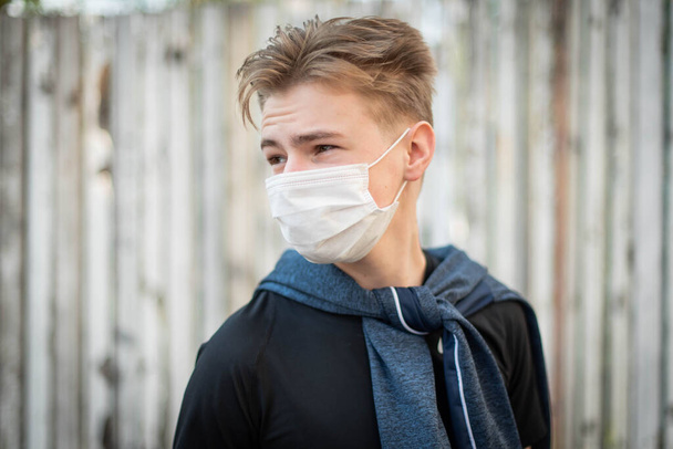 外科用包帯に身を包んだ可愛い10代の少年。コロナウイルス,病気,感染症,隔離,医療用マスク, COVID-19.医者のマスクの少年。隔離と保護ウイルス,インフルエンザ,流行｜COVID-19. - 写真・画像