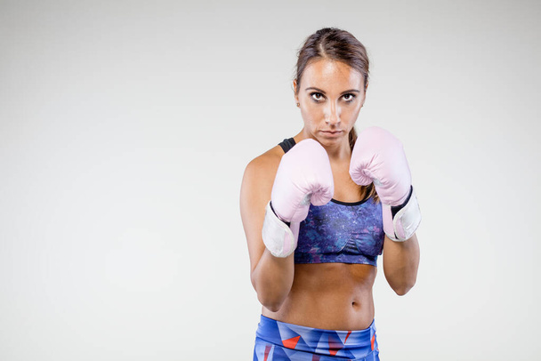 girl kickboxer posing with pink gloves - Fotoğraf, Görsel