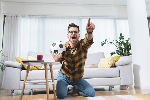 Male football fan celebrating goal or victory at home - Foto, imagen