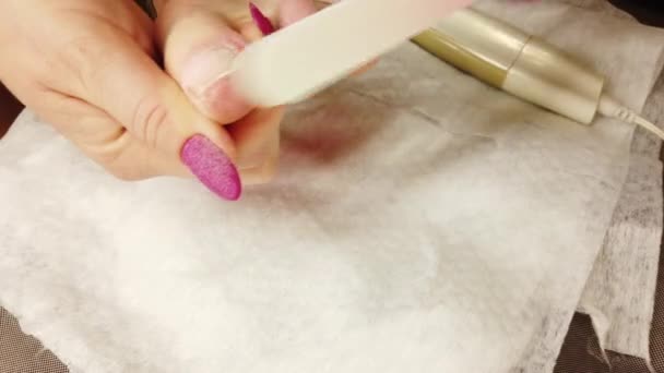 Dziewczyna w domu robi pedicure, poleruje paznokcie u nóg specjalną szlifierką, manicure sprzętowy. - Materiał filmowy, wideo