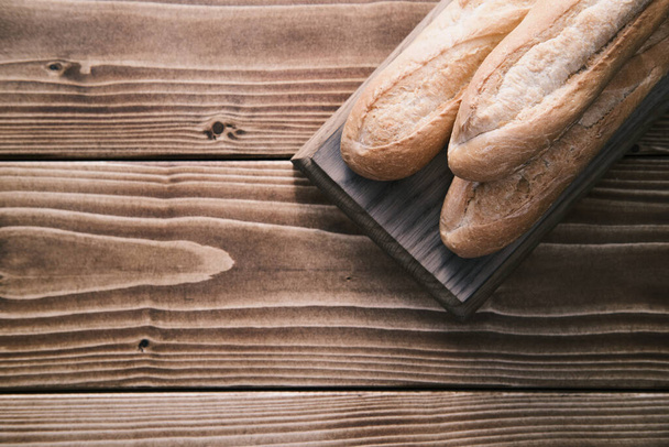 Fresh french baguette on wooden board. ready to eat - Fotoğraf, Görsel