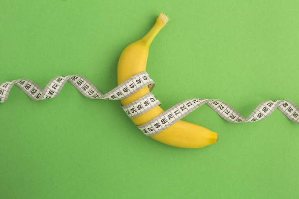 Fechar em banana e centímetro branco no fundo verde - Foto, Imagem