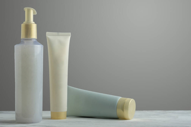 Kit de cremas para el cuidado facial, que incluye diversos productos para el cuidado de la piel, sobre una base de mármol y fondo degradado. - Foto, imagen