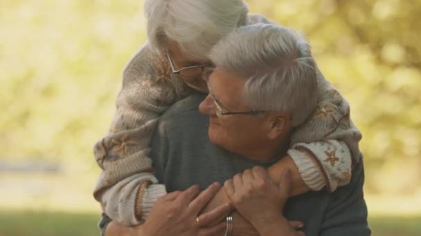 Buone vecchie coppie che si abbracciano al parco. Uomo anziano che flirta con una donna anziana. Romanticismo a ballo di vecchiaia durante giorno di autunno - Filmati, video