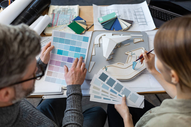 Interior designers team working in office with color palette. Architects select colors for building using color swatches, sketching and planning construction project. Partners discussing at work - Foto, Imagem